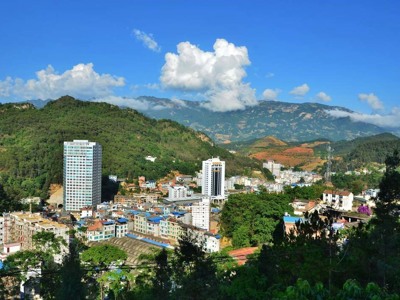 Stadsgezicht van Sapa met groene bergen en wolkenlucht tijdens de Route China & Vietnam, 20 dagen.
