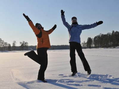 Twee reizigers springen in de sneeuw bij Kylmäluoma in Lapland, Finland.