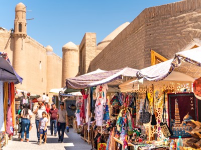 Marktkraampjes met kleurrijke souvenirs langs de oude stadsmuur van Khiva, Route Oezbekistan.