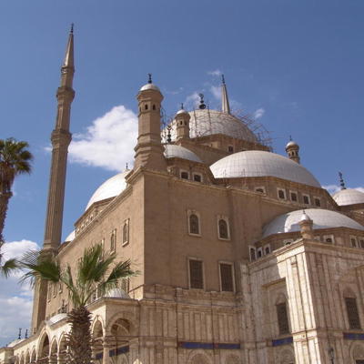 Moskee van Mohammed Ali in Caïro met koepels en minaretten onder een blauwe lucht.