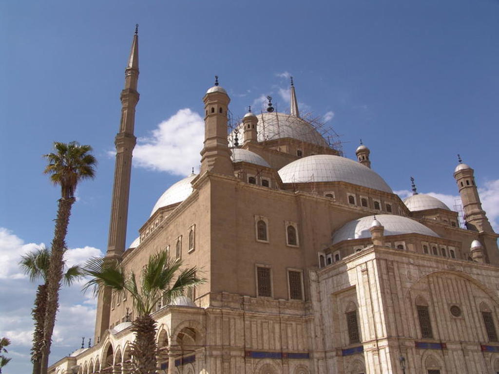 Moskee van Mohammed Ali in Caïro met koepels en minaretten onder een blauwe lucht.