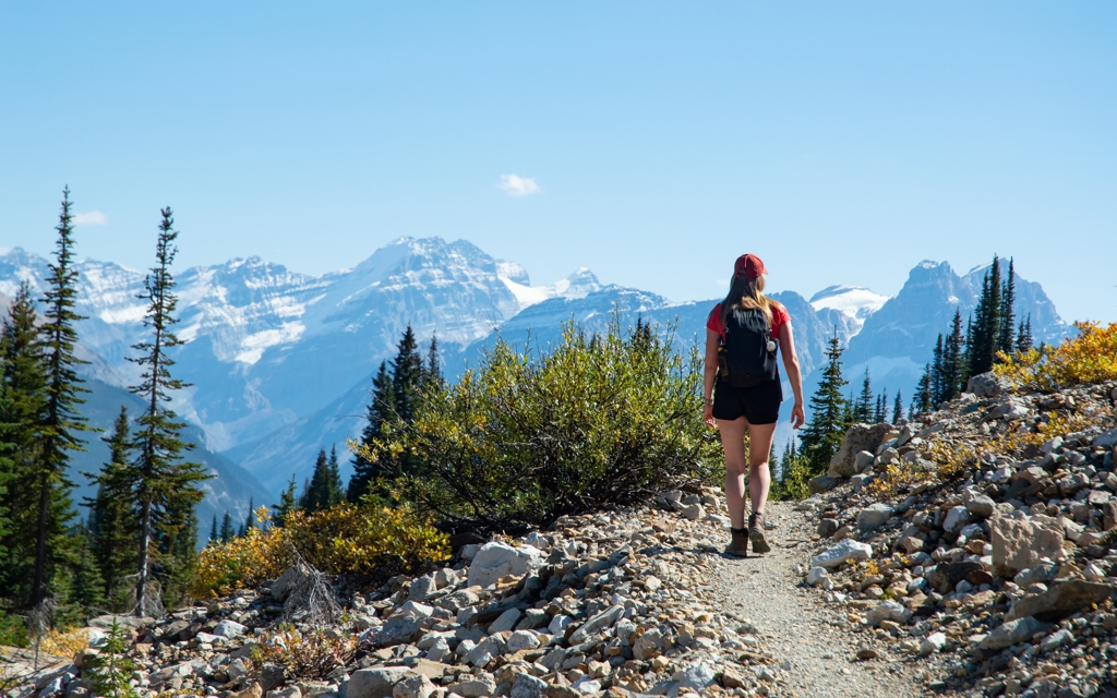 Wandelaar op bergpad met uitzicht op de Canadese Rockies tijdens familiereis Canada West.
