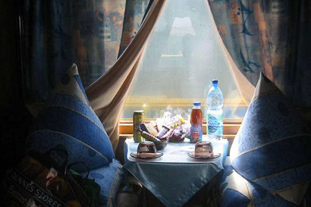 Coupé in de trein tijdens groepsrondreis Rusland winter, met gedekte tafel en uitzicht door het raam.