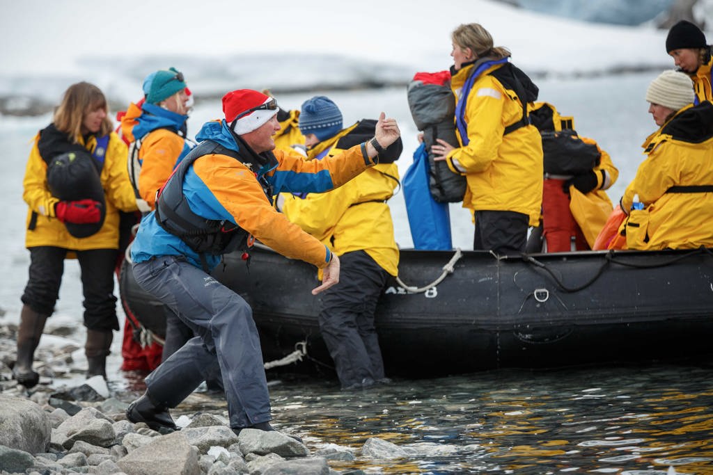 Reizigers stappen in een zodiac rubberboot bij Disko Bay, Groenland, tijdens een groepsrondreis.
