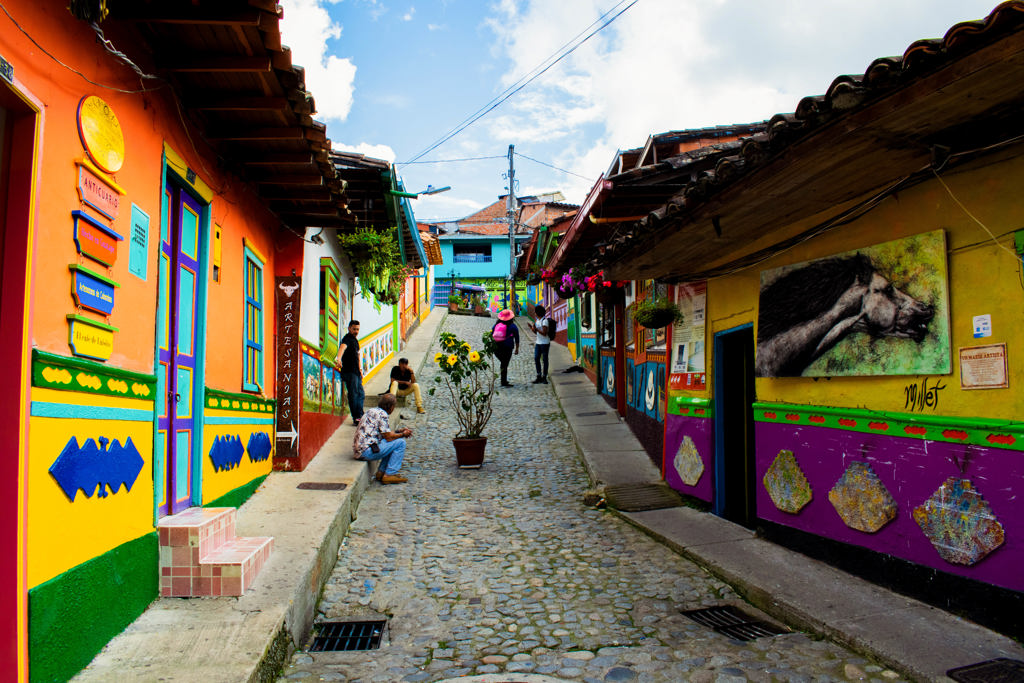 Kleurrijke straat met muurschilderingen en kasseien in Guatapé tijdens een 22-35ers reis door Colombia.