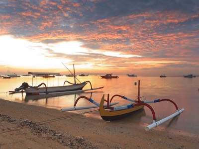 Traditionele vissersbootjes bij zonsopkomst aan het strand van Bali tijdens de route Java en Bali.
