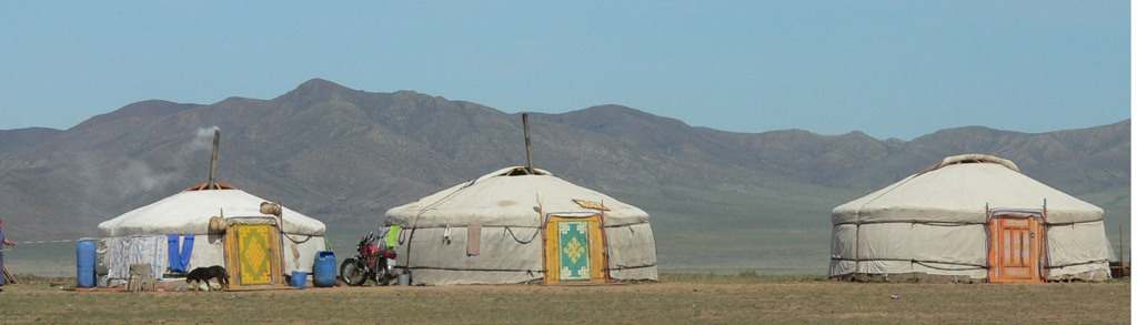 Traditionele gers (joerten) op de Mongoolse steppe met bergen op de achtergrond tijdens een groepsrondreis Mongolië.