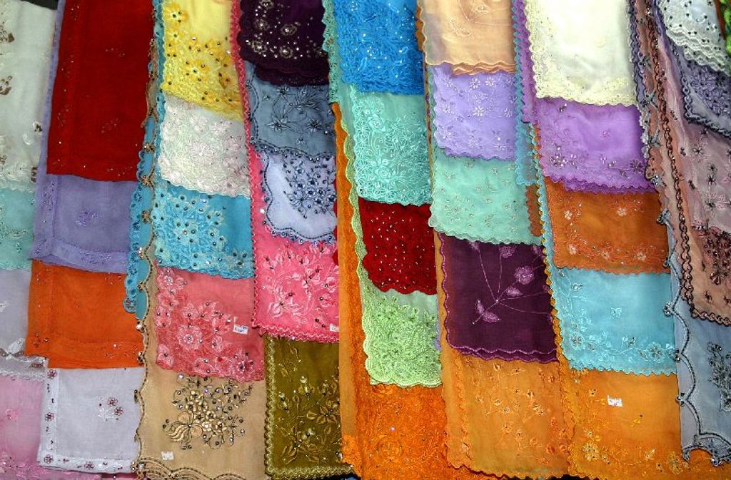 Kleurrijke batik- en kantstoffen op een markt in Maleisië tijdens de rondreis Maleisië Hoogtepunten.