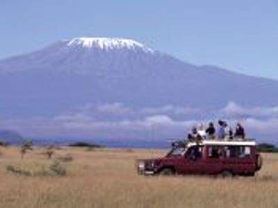 Safari-jeep op de savanne met de besneeuwde top van de Kilimanjaro op de achtergrond tijdens Route Kenia.