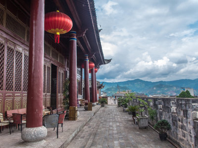 Traditioneel Chinees tempelgebouw met rode lantaarns en uitzicht op bergen tijdens route China.