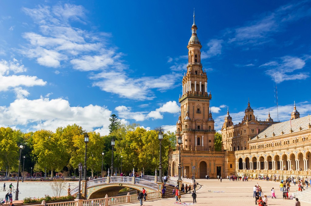 Plaza de España in Sevilla tijdens familiereis Andalusië, met brug en toren onder blauwe lucht.