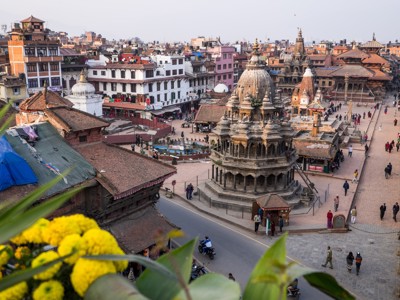Uitzicht over Patan Durbar Square in Nepal met tempels, pleinen en wandelende mensen.