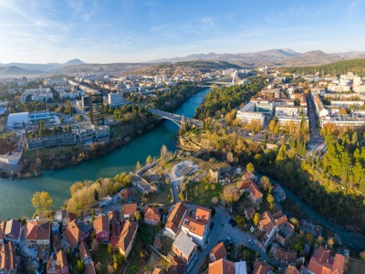 Panoramisch uitzicht op Podgorica met de Morača-rivier, bruggen en bergen in Montenegro.