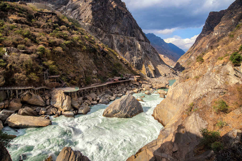 Bergkloof met wilde rivier en wandelpad langs de rotsen tijdens een groepsrondreis China.