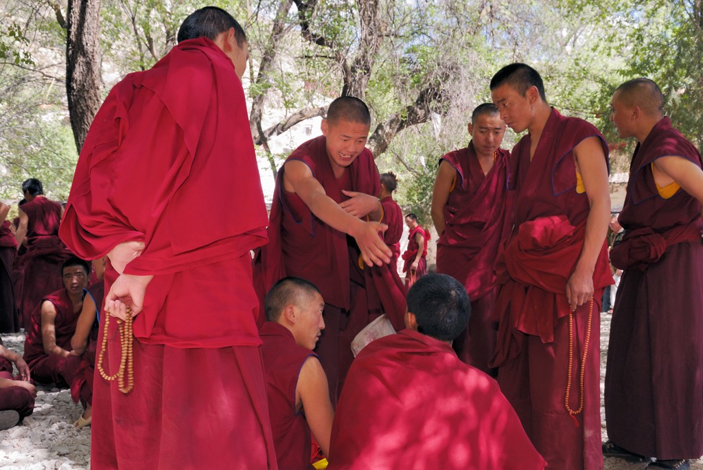 Tibetaanse boeddhistische monniken in rode gewaden in gesprek bij een klooster, tijdens groepsrondreis Tibet en Nepal.