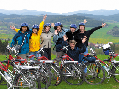 Groep fietsers met helmen poseert bij fietsen met uitzicht op groene heuvels tijdens fietsvakantie Kroatië en de Balkan.