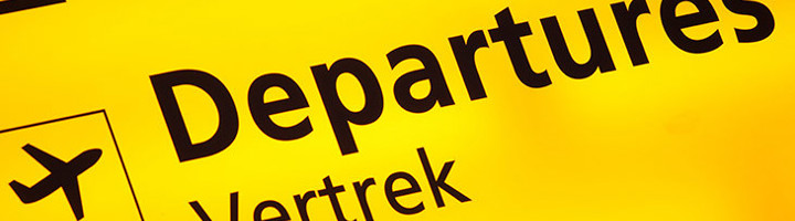 Gele luchthavenbord met “Departures” en “Vertrek” als verwijzing naar wachttijden op Schiphol.