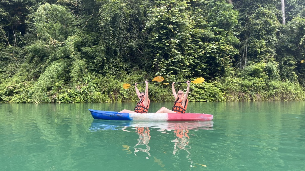 Twee reizigers kajakken op een groen meer in Thailand tijdens een 22-35ers groepsrondreis.