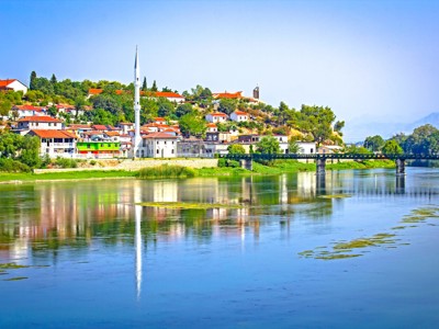 Uitzicht op Shkodër in Albanië met moskee en brug langs het Skadarmeer.