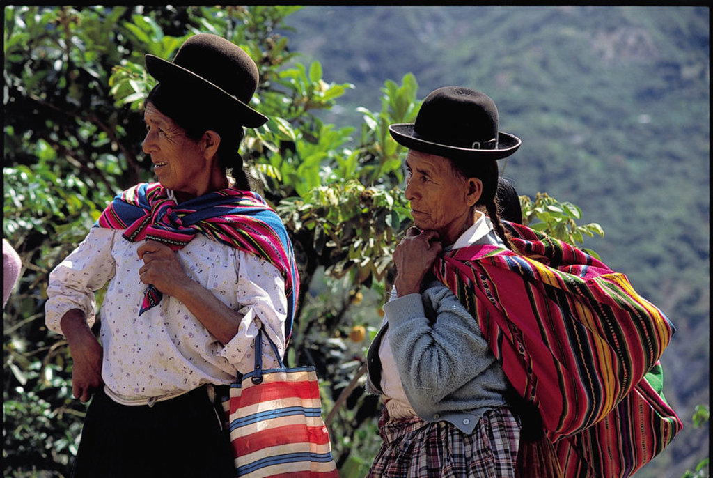 Twee vrouwen in traditionele kleding met bolhoed en kleurrijke draagdoek in Bolivia tijdens groepsrondreis Bolivia en Chili.