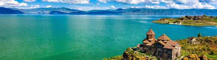 Klooster Sevanavank aan het Sevanmeer in Armenië, met uitzicht op het blauwe meer en bergen.