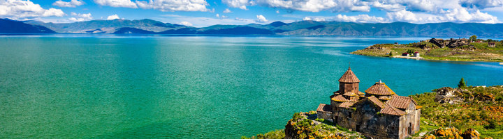 Klooster Sevanavank aan het Sevanmeer in Armenië, met uitzicht op het blauwe meer en bergen.