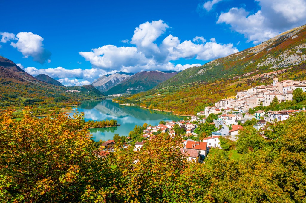 Uitzicht op een bergmeer en dorp in de Centrale Apennijnen tijdens een wandelvakantie in Italië.