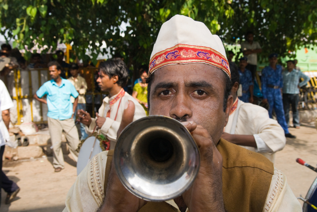 Muzikant speelt trompet tijdens een straatoptreden in India.