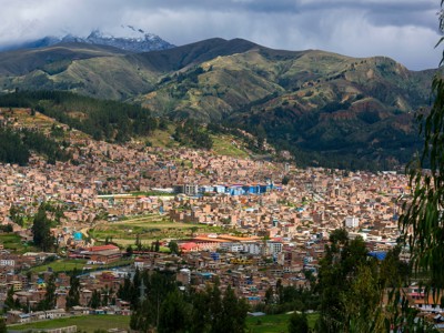 Panorama van Cajamarca in Noord-Peru, met de stad in een vallei en groene bergen op de achtergrond.