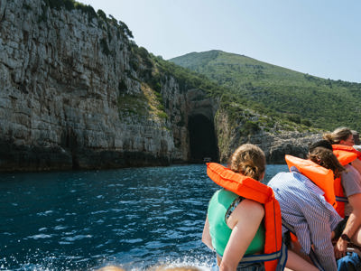 Boottocht langs rotskliffen en zeegrot aan de Albanese kust tijdens 22-35ers groepsrondreis Albanië.