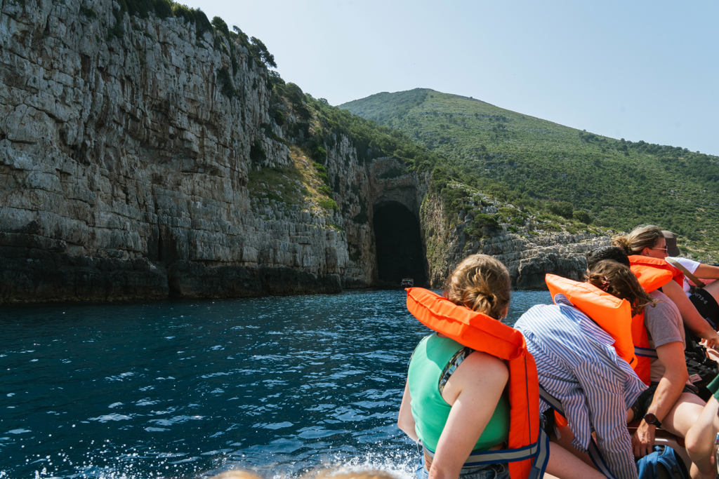 Boottocht langs rotskliffen en zeegrot aan de Albanese kust tijdens 22-35ers groepsrondreis Albanië.
