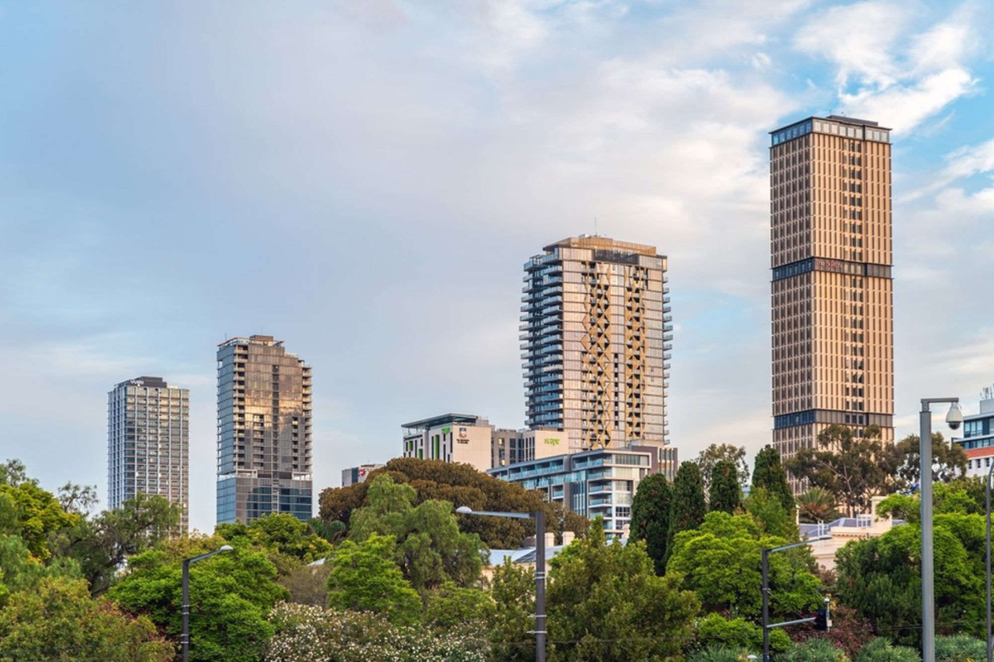 Skyline van Melbourne met moderne wolkenkrabbers boven groene bomen in Australië.