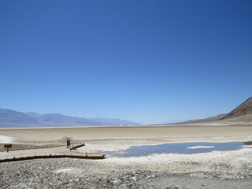Uitzicht over Badwater Basin in Death Valley, met zoutvlakte, waterplas en wandelpad in het westen van de VS.