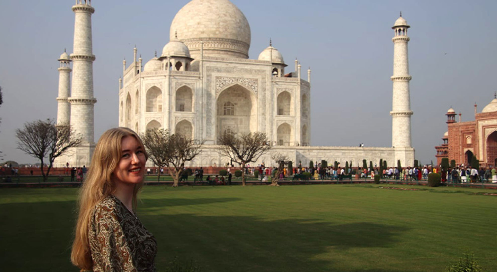 Vrouw poseert voor de Taj Mahal in Agra, India.