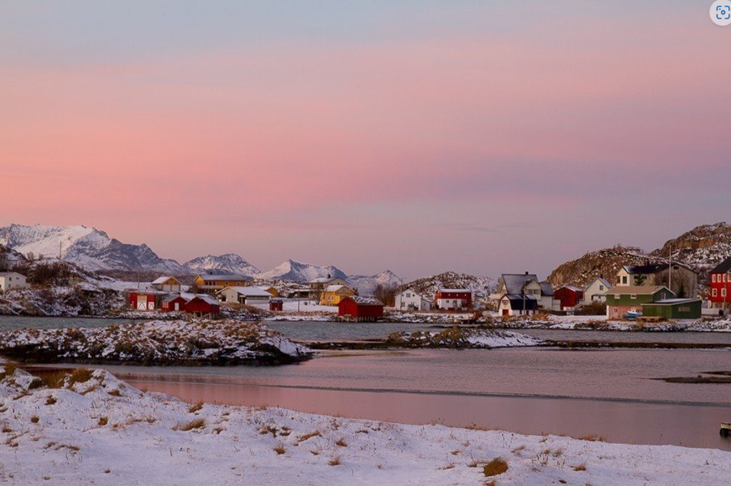 Sneeuwlandschap met vissersdorp en bergen op de Lofoten, Noorwegen, bij zonsondergang.