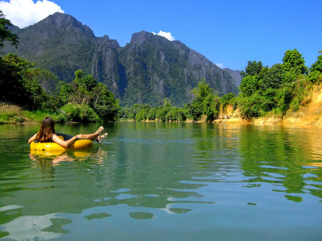 Tubing op een rivier met kalksteenbergen in Laos tijdens de 22-35ers reis Thailand, Laos & Cambodja.