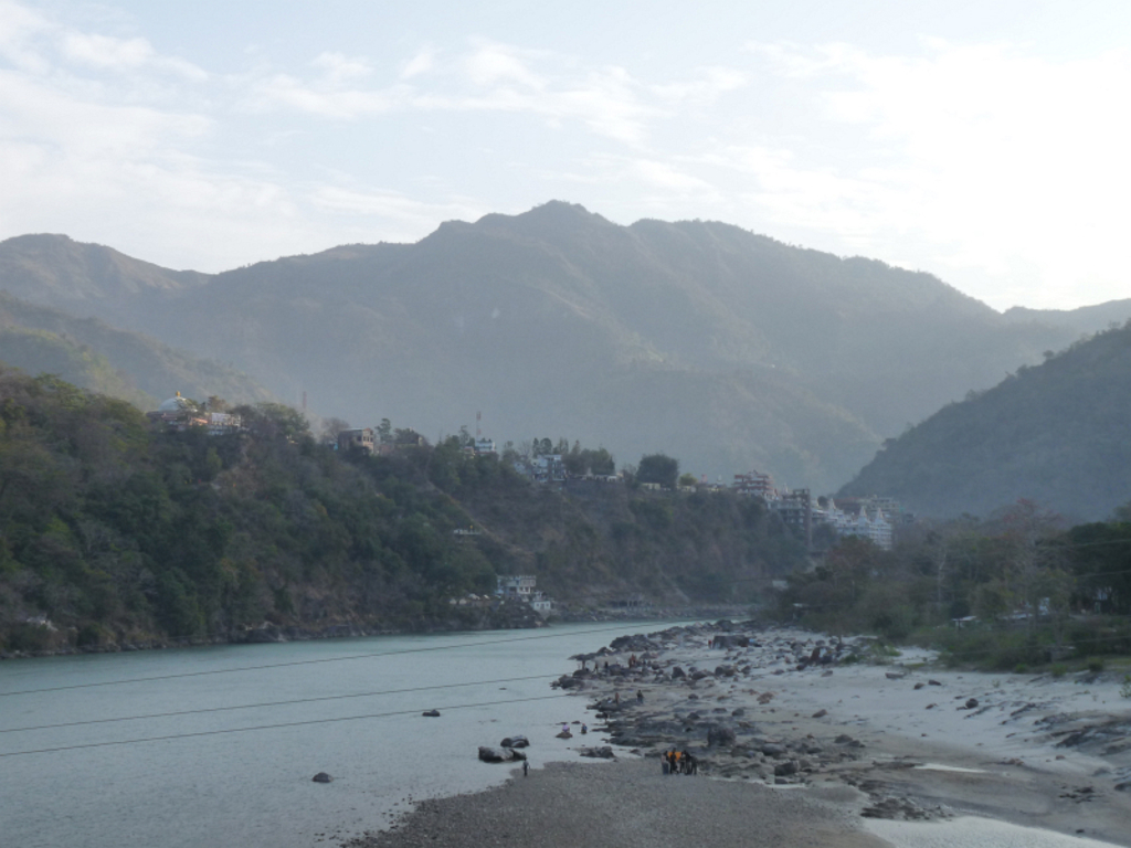Uitzicht op de Ganges met heuvels en bebouwing langs de rivier in India tijdens een groepsrondreis tijgerreis.