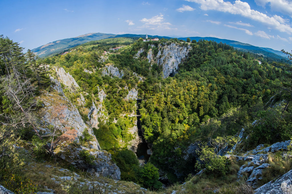 Uitzicht over een groene kloof met rotswanden en heuvels in Slovenië tijdens een 22-35ers groepsrondreis.