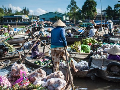 Drukke drijvende markt in de Mekongdelta, Vietnam, met boten vol groente en fruit.