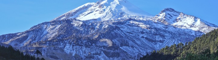 Besneeuwde top van de vulkaan Pico de Orizaba in Mexico onder een heldere blauwe lucht.