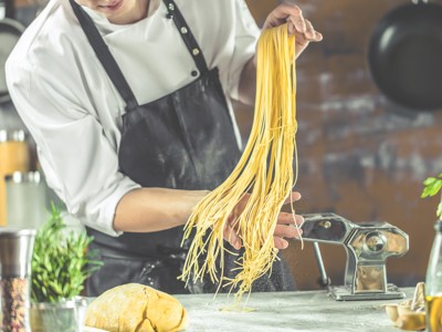 Kok maakt verse pasta met pastamachine tijdens dag 11 van de rondreis Amalfikust, Cilento en Sicilië.