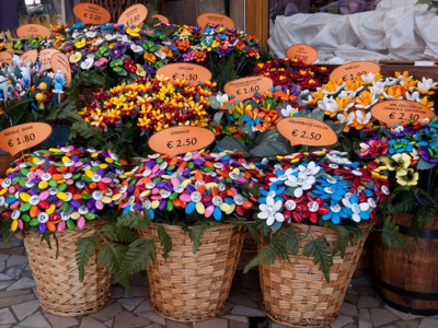 Kleurrijke keramieken bloemen en souvenirs in manden op een markt in de Centrale Apennijnen, Italië.