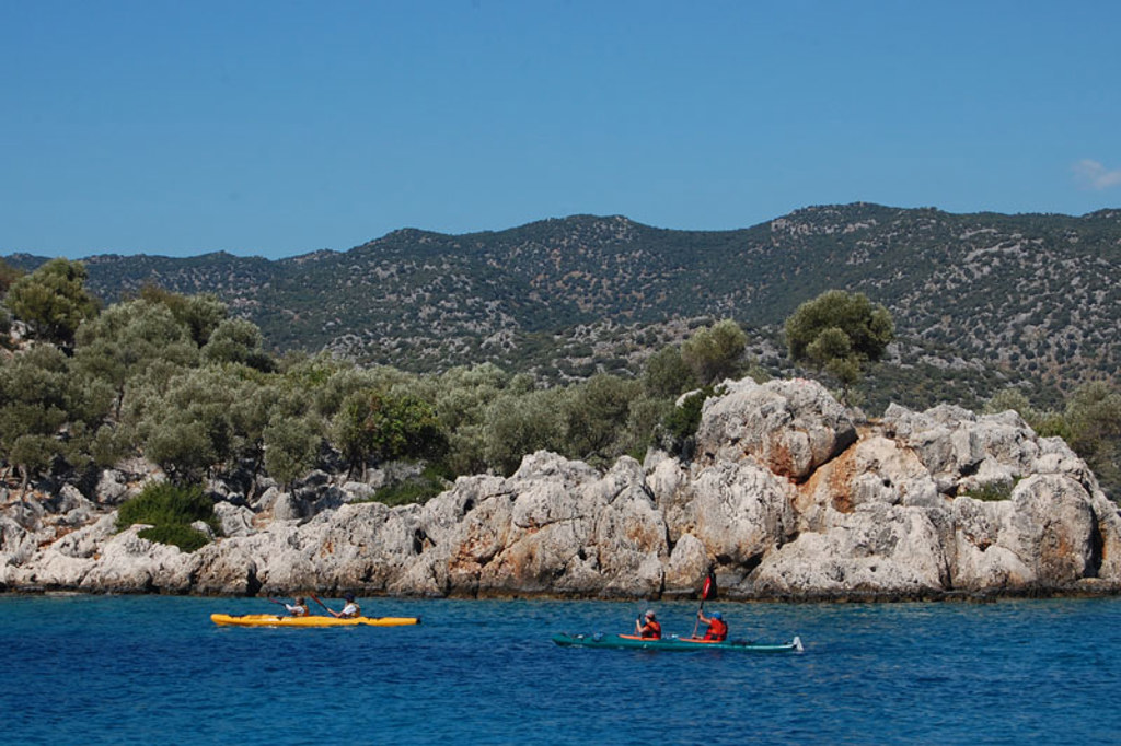 Kajakkers op zee langs de rotsachtige kust van Zuid-Turkije tijdens een familiereis.