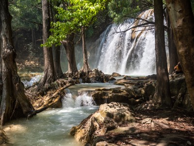 Waterval in het bos bij Agua Azul, Mexico, met helderblauw water en rotsen langs de rivier.