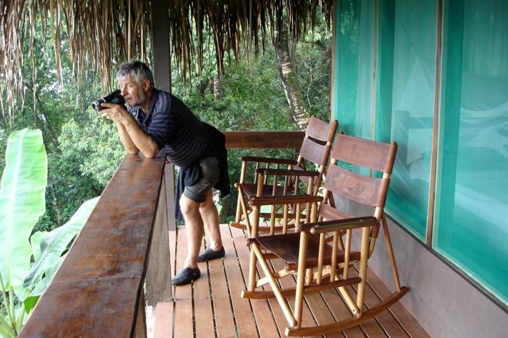Reiziger spot vogels vanaf een lodgebalkon in het regenwoud van Costa Rica.