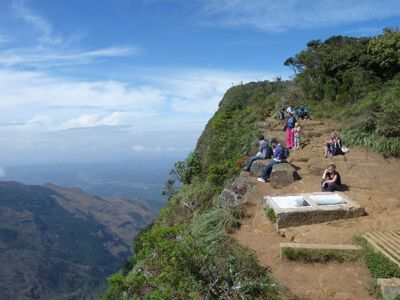Uitzichtpunt op de klif bij World’s End in Horton Plains, Sri Lanka, met wandelaars en uitzicht over de vallei.