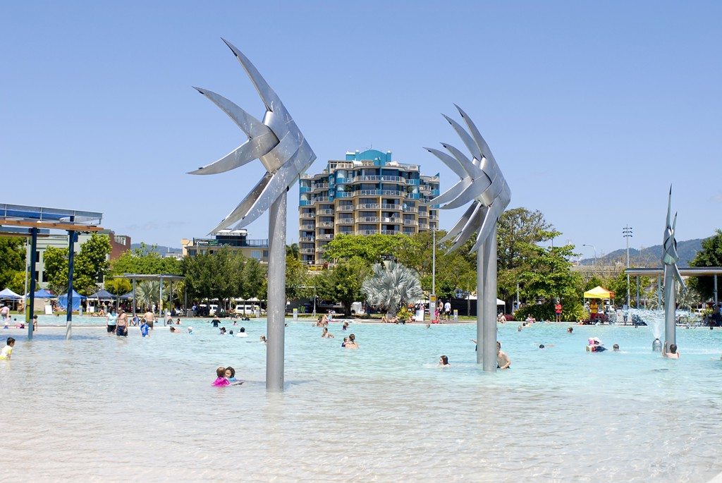 Lagunezwembad in Cairns, Australië, met zwemmers en moderne sculpturen.