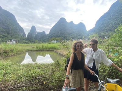 Twee reizigers met fiets bij rijstveld en karstbergen in Guilin, China.