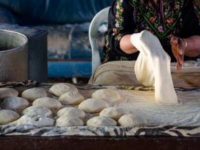 Vrouw kneedt deeg en vormt broodjes tijdens route Armenië en Georgië, 18 dagen.