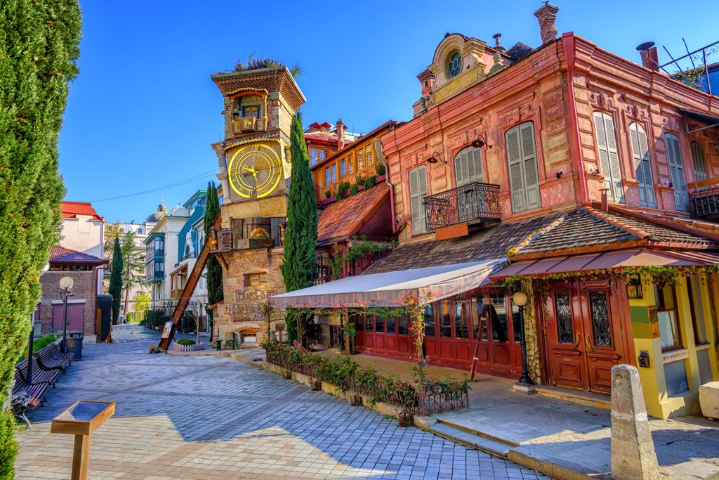 Klokkentoren met theaterpoppen en kleurrijke oude huizen in Tbilisi, Georgië.
